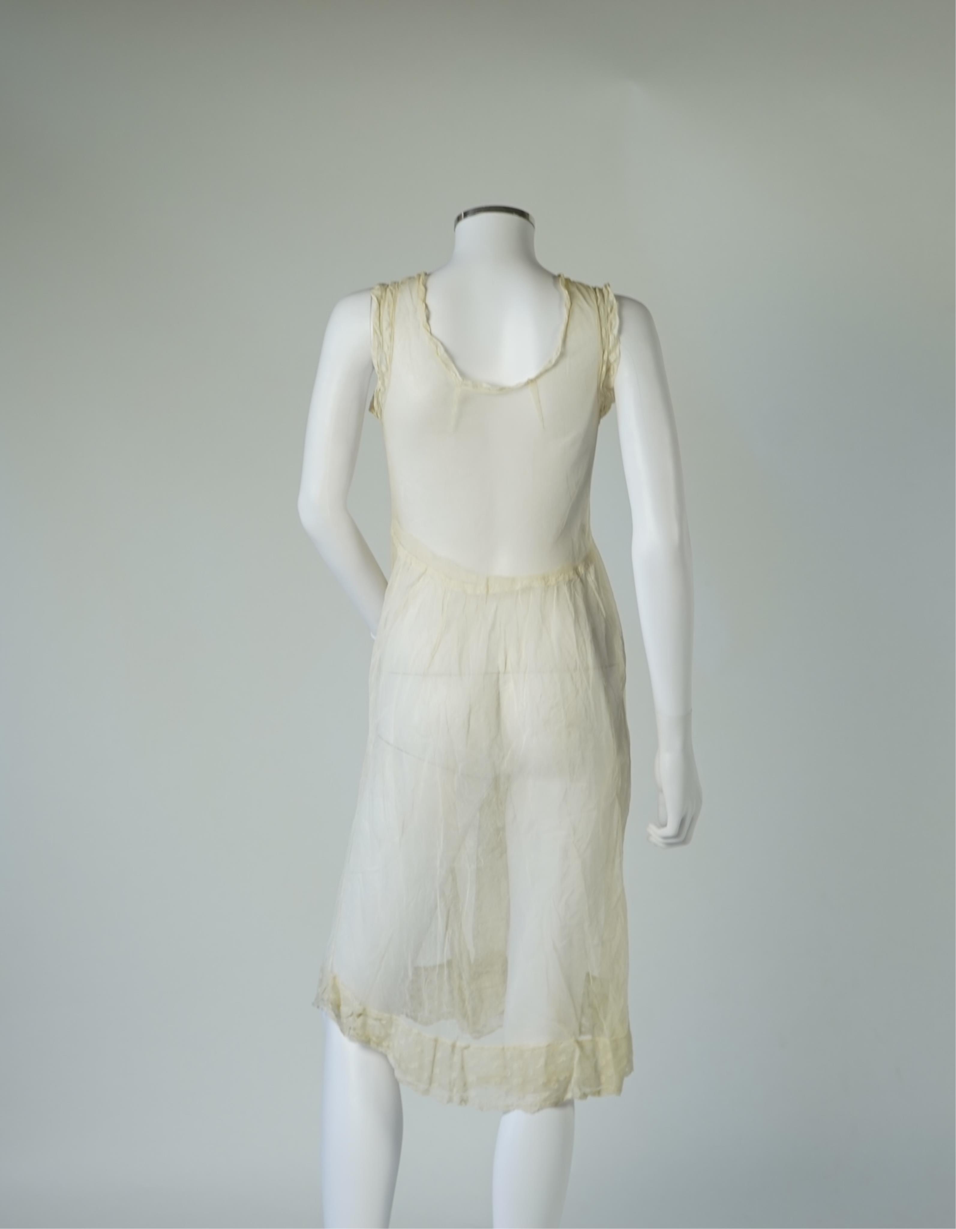 An early 20’s cream net ladies summer dress and net petticoat, designed with a lace inset front skirt, yolk and sleeves.103cm long. Condition - both need re-laundering and some seams tidying.